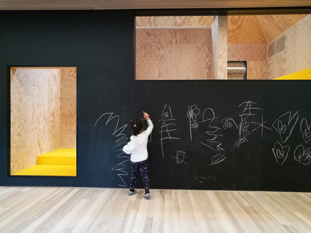 Child paints a black wall with a door opening and a window opening