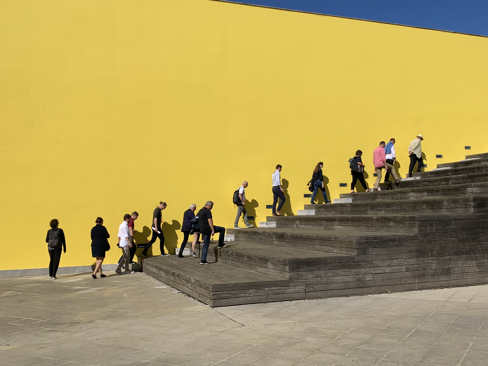 Group of people in front of a yellow facade