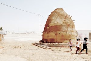 Kinder in sandiger Umgebung und Erdhügel