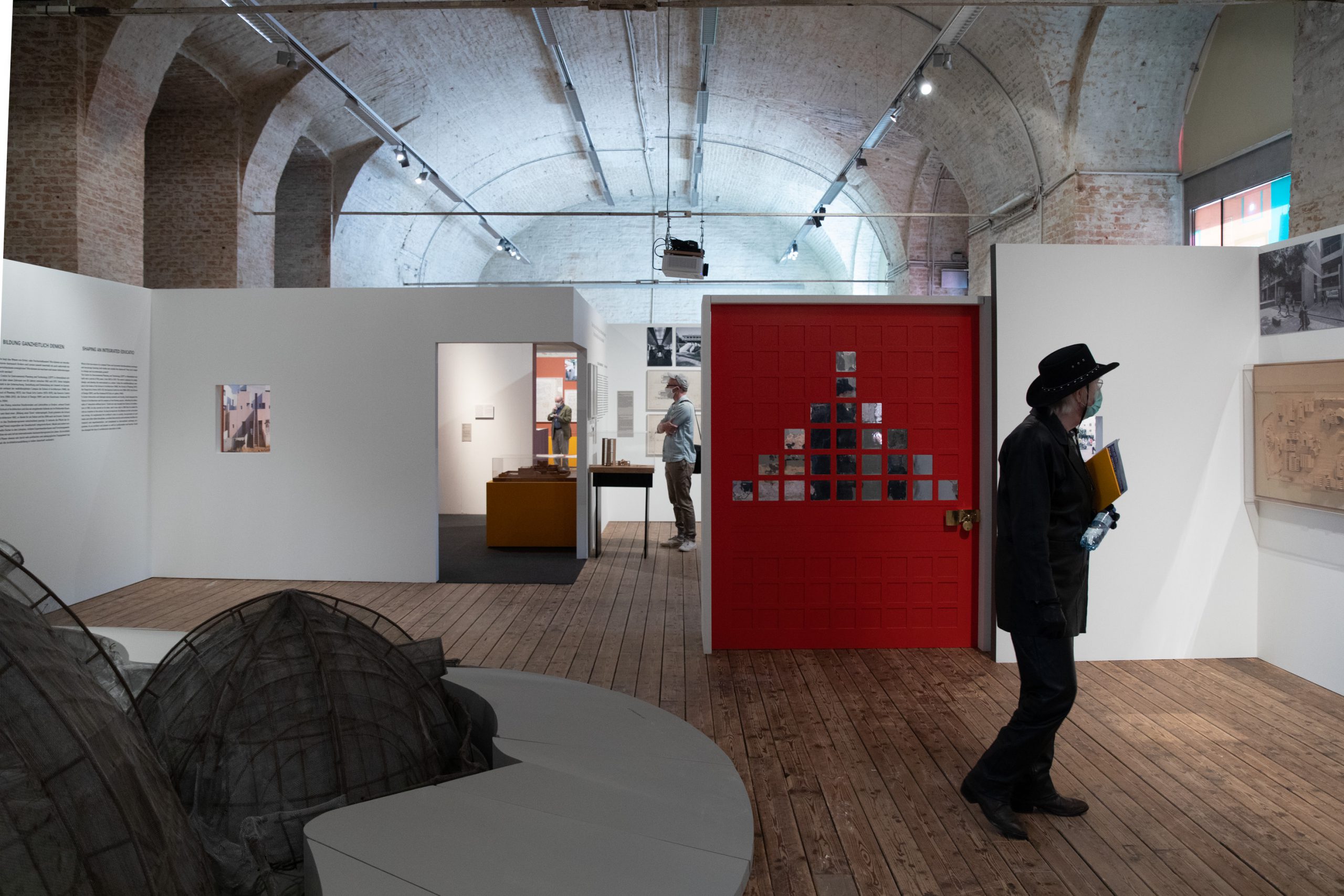 man with black hat and black clothes in exhibition room