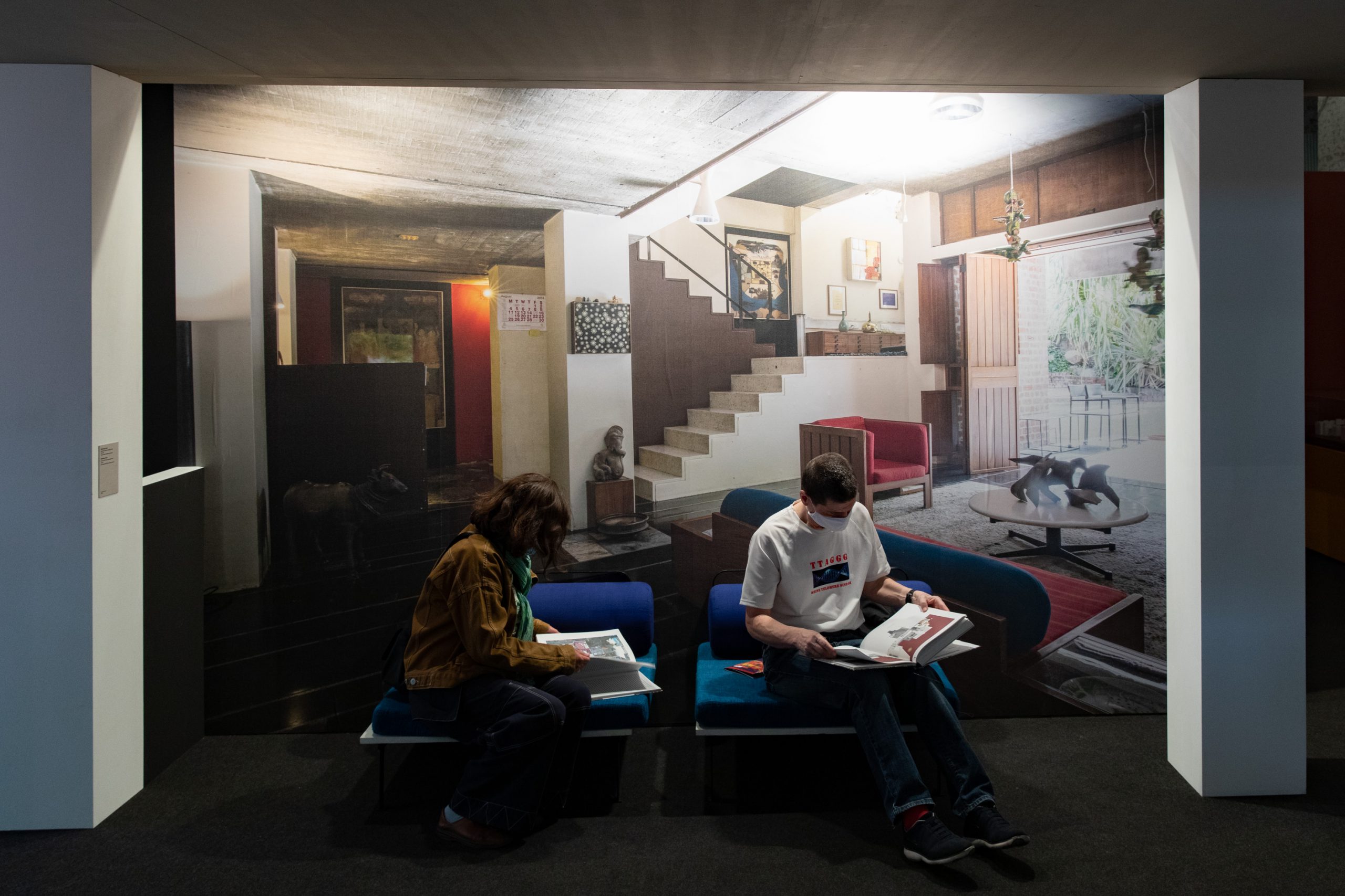 2 persons reading on a blue sofa