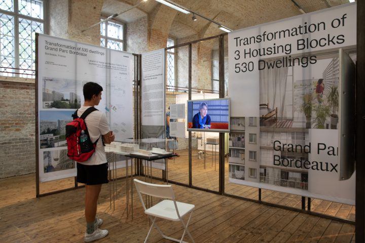 Man with red backpack in front of the screen in the exhibition room