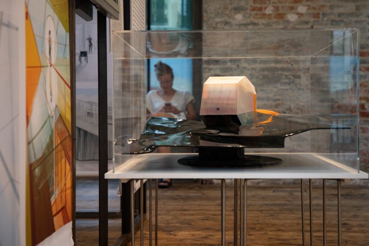 Woman behind an architectural model with shiny black background