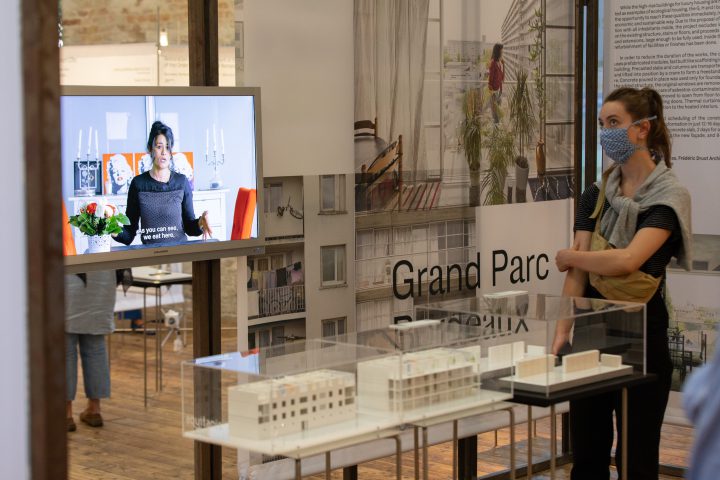 Woman with ponytail and mouth guard next to a screen in an exhibition