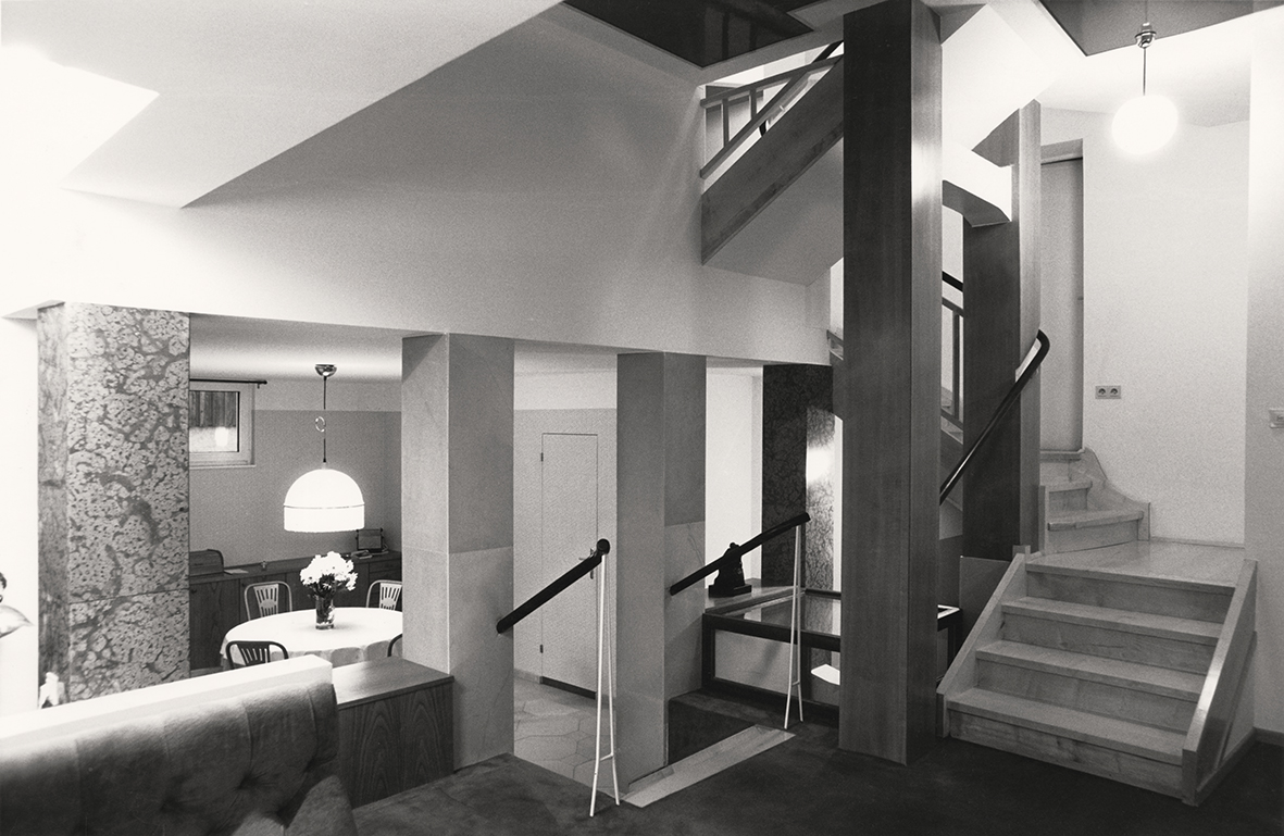 Interior photo black and white with open staircase, lamp and round table