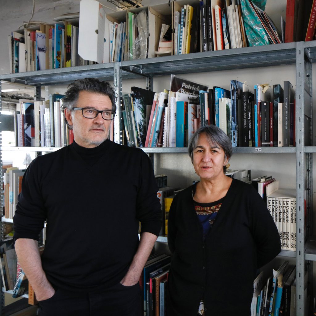 1 man with glasses and 1 woman, both dressed in black