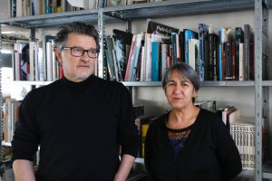 1 man with glasses and 1 woman, both dressed in black