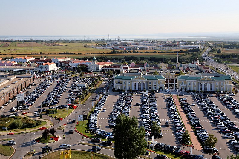 many cars on a parking lot with houses in between