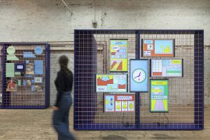 Woman walking in front of walls with colorful pictures in an exhibition