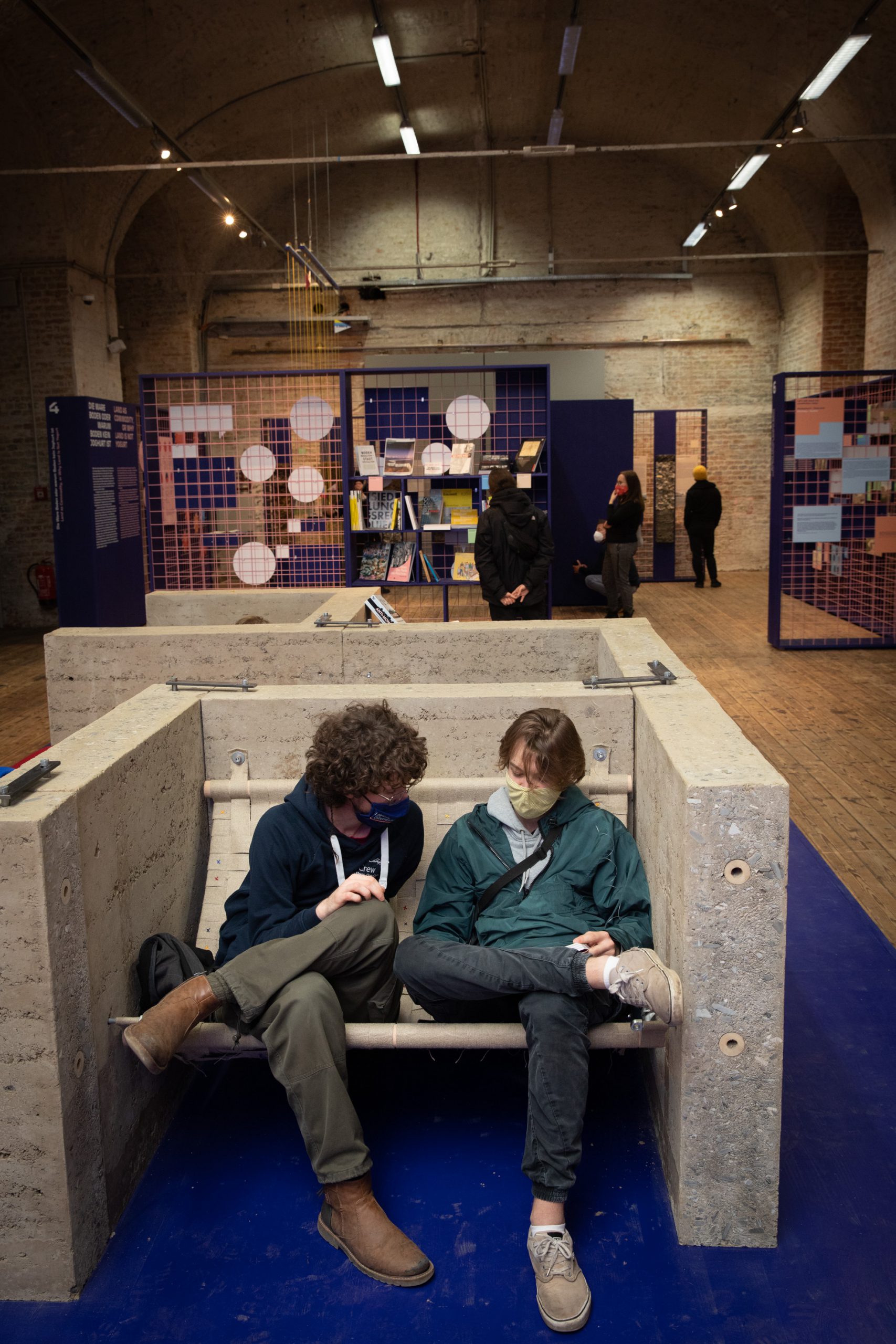 2 people sitting in a bunk made of concrete