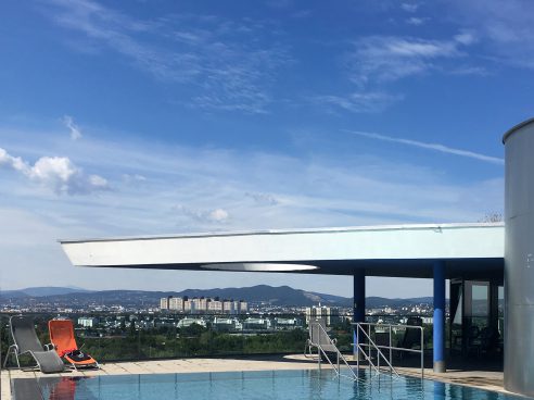 Pool on the roof of a high-rise building with 2 sun loungers