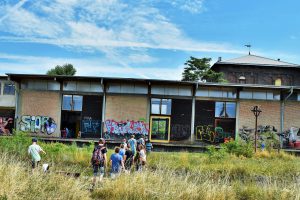 a group of people in front of a building with graffiti