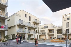 Wohnhäuser in beige mit Balkonen und kleinem Innenhof-Spielplatz