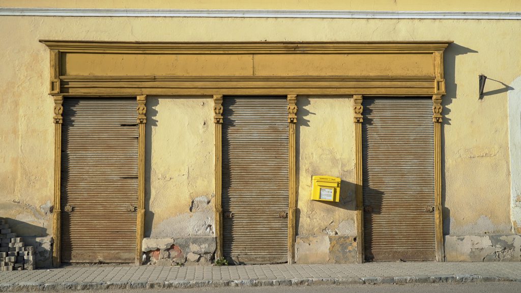 Fassade mit geschlossenem Geschäftsportal und schiefem Briefkasten