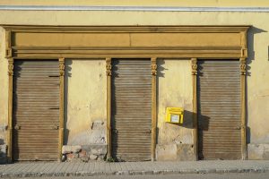 Fassade mit geschlossenem Geschäftsportal und schiefem Briefkasten