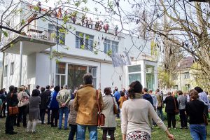 viele Menschen in einem Garten vor und in einem weißen Haus