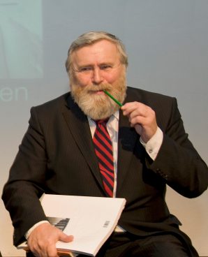 Mann mit rot-schwarz gestreifter Krawatte und Bleistift im Mund