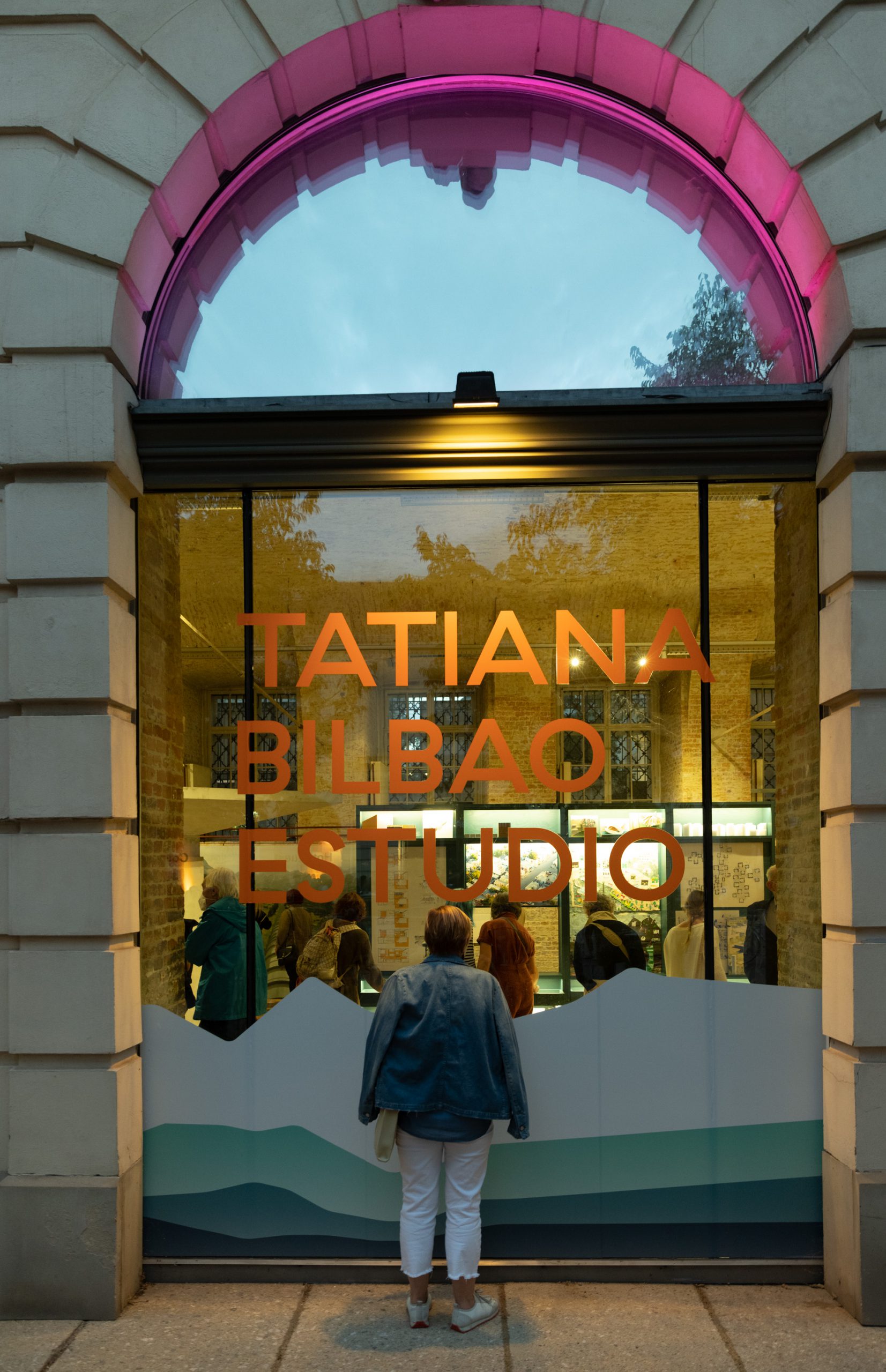 Fenster mit Schriftzug "Tatiana Bilbao Estudio", ein Mensch schaut hinein