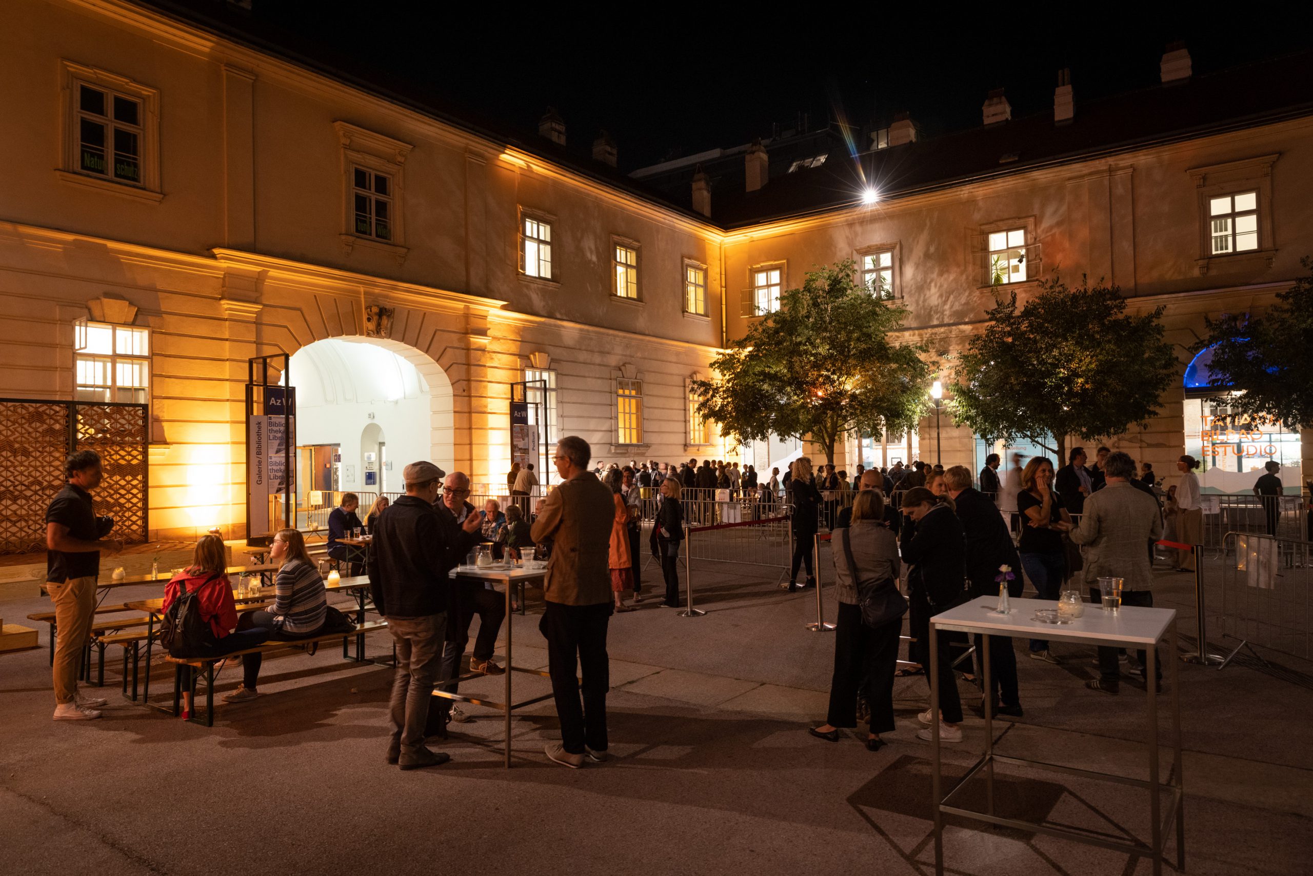 many people in the evening at a party in a courtyard
