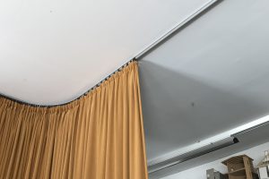 Ein brauner Vorhang auf einer gebogenen Vorhangschiene