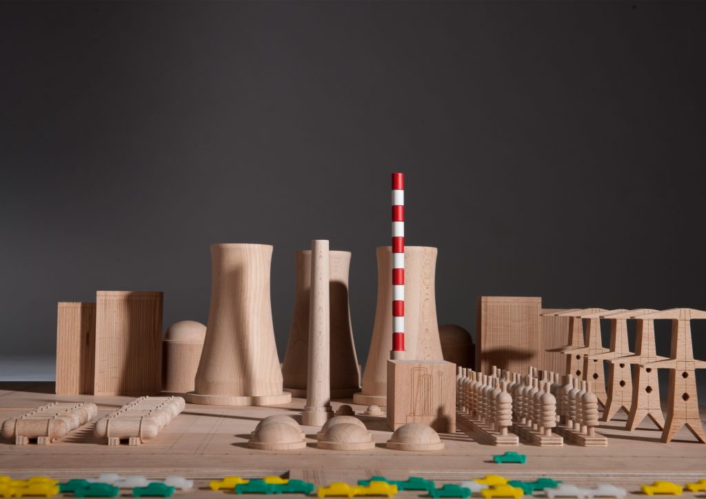 wooden model with nuclear power plant cooling towers and red and white striped tower