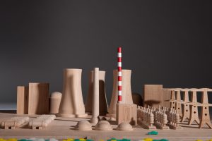 wooden model with nuclear power plant cooling towers and red and white striped tower