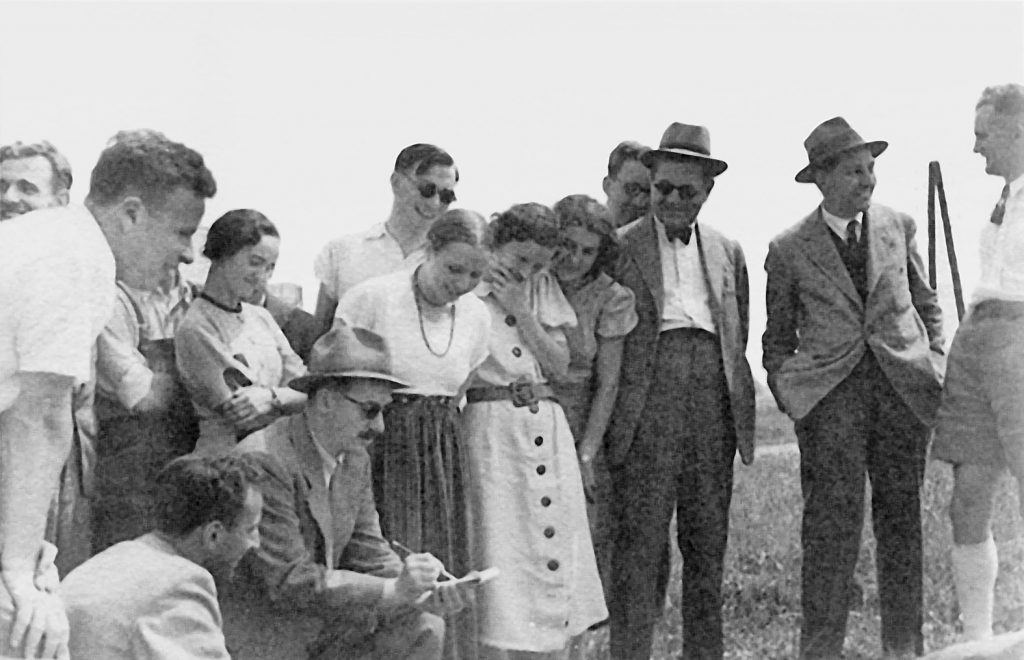 altes schwarz-weiß Foto mit Männern und Frauen die in einer Gruppe zusammenstehen
