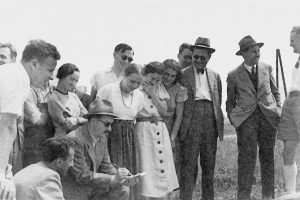 altes schwarz-weiß Foto mit Männern und Frauen die in einer Gruppe zusammenstehen