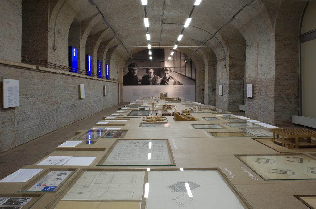 Showroom with large table with plans and drawings and blue panels on the sides