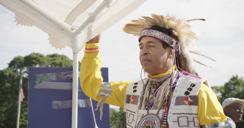 Man with feather headdress and colourful robe