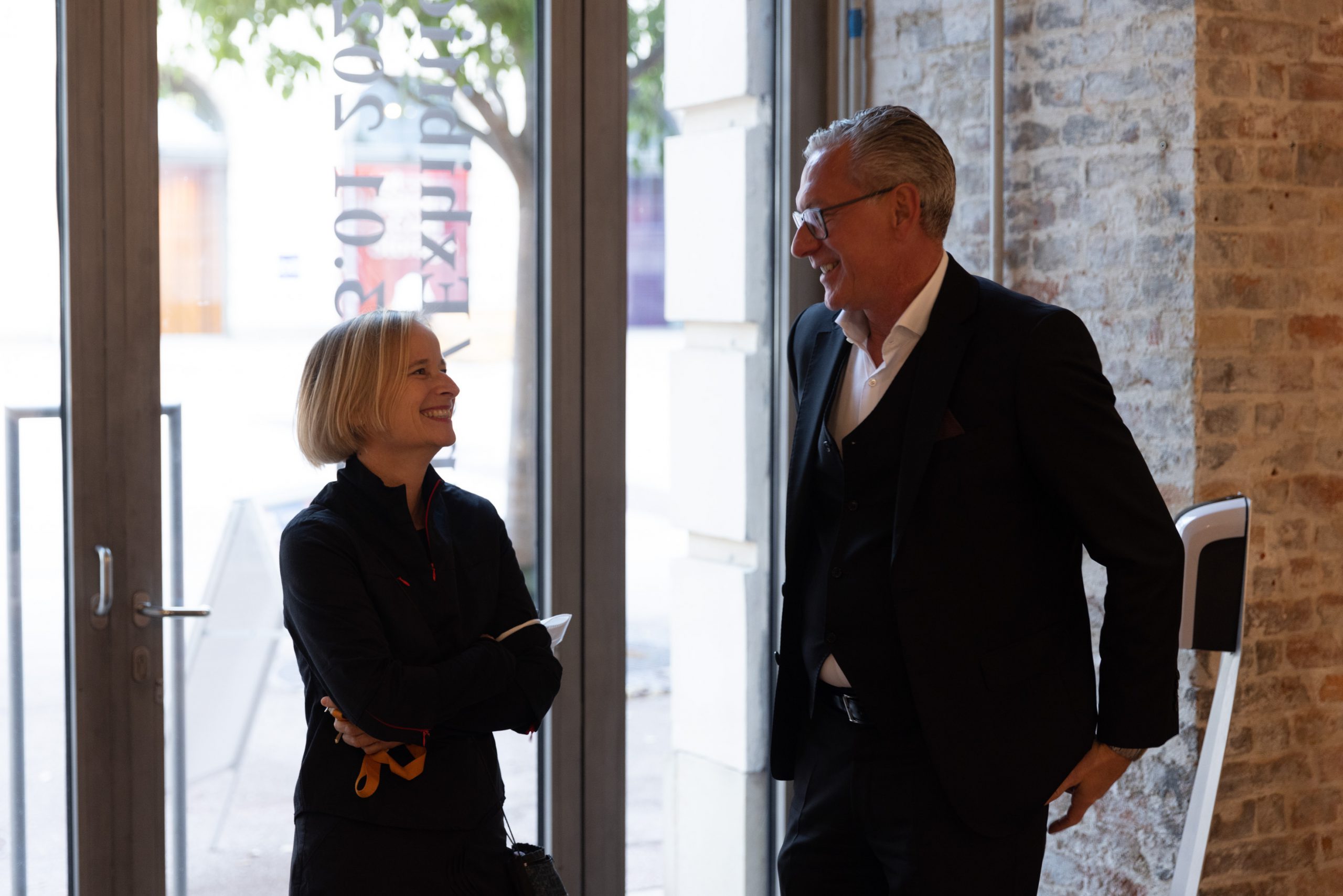 a woman and a man talking and laughing together