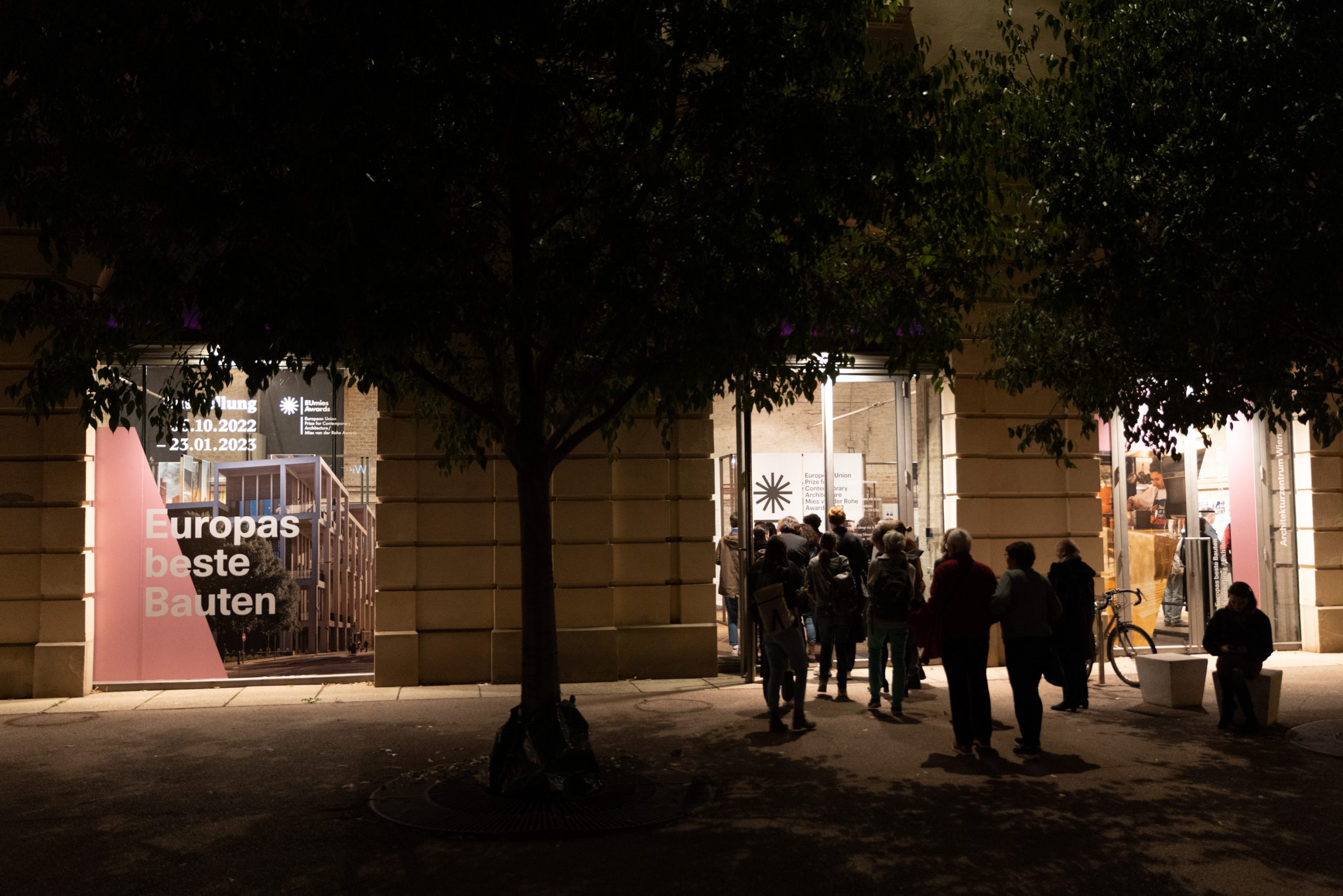 Inner courtyard at night with many people in front of the entrance