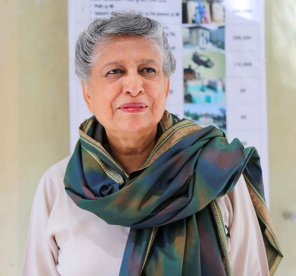 Older woman with gold embroidered scarf around her neck