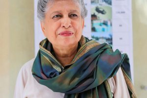 Older woman with gold embroidered scarf around her neck