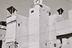schwarz-weiß Foto mit zusammenhängenden Häusern mit Windfängen am Dach