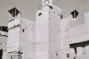 black and white photo with connected houses with windbreaks on the roof