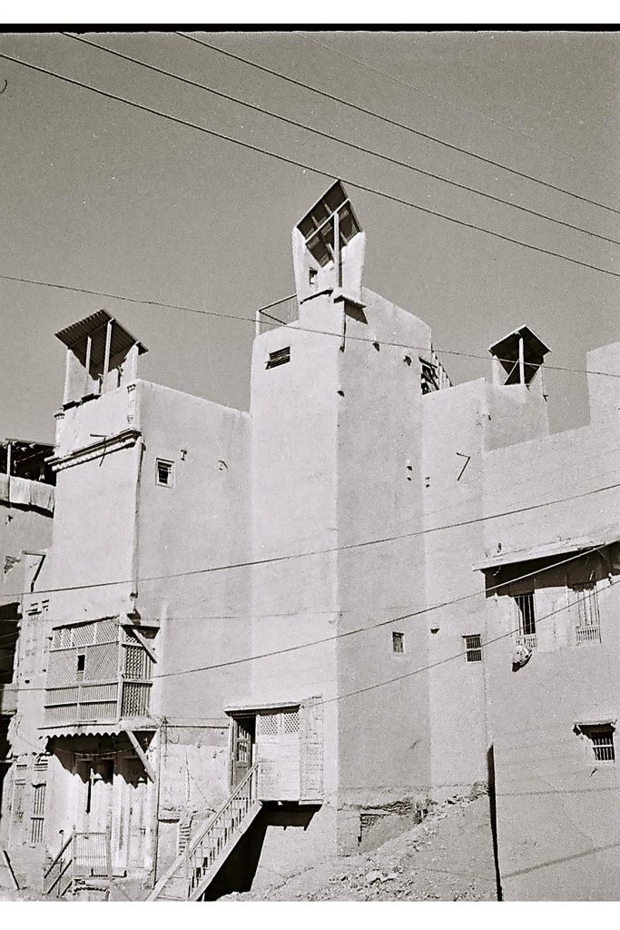schwarz-weiß Foto mit zusammenhängenden Häusern mit Windfängen am Dach