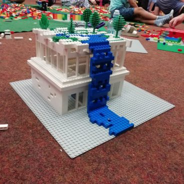 Haus aus Legosteinen auf einem braunen Untergrund