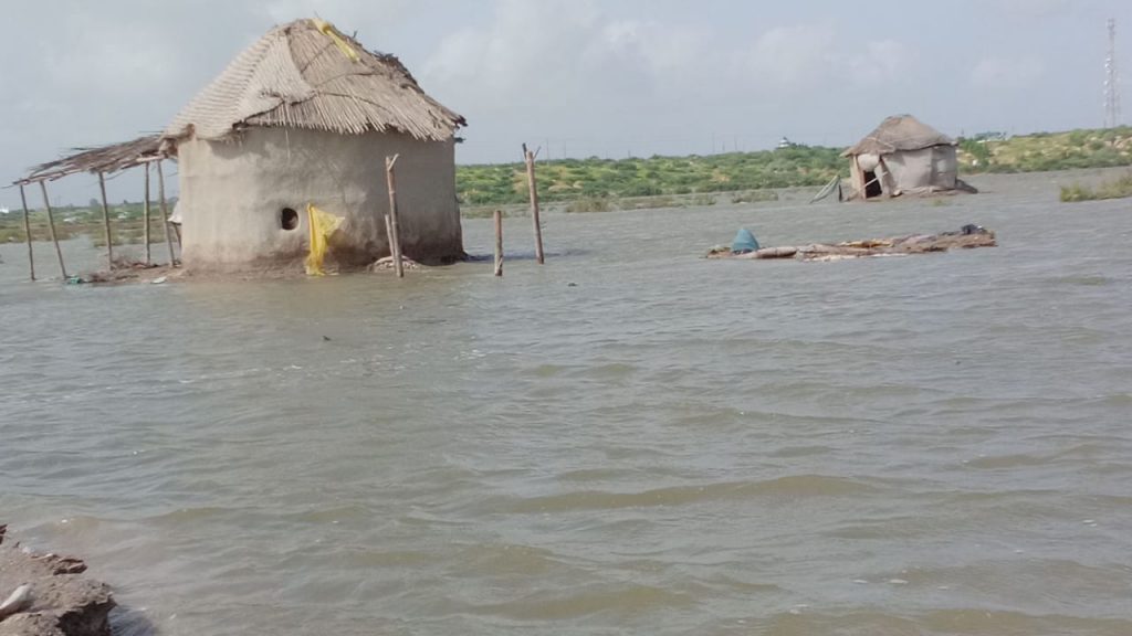 Lehmhütten mit Strohdächern unter Wasser