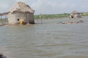 Lehmhütten mit Strohdächern unter Wasser