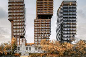 3 modern high-rise buildings standing on a river bank