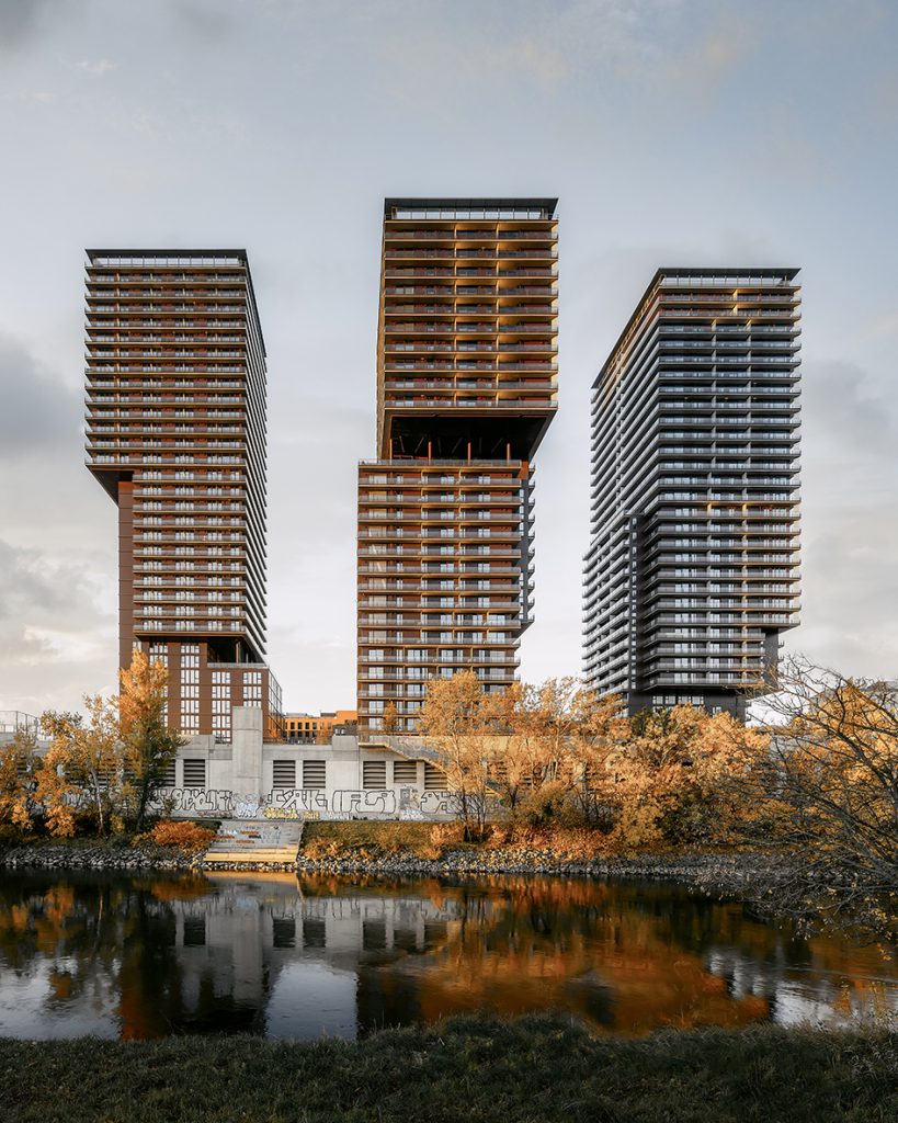 3 modern high-rise buildings standing on a river bank