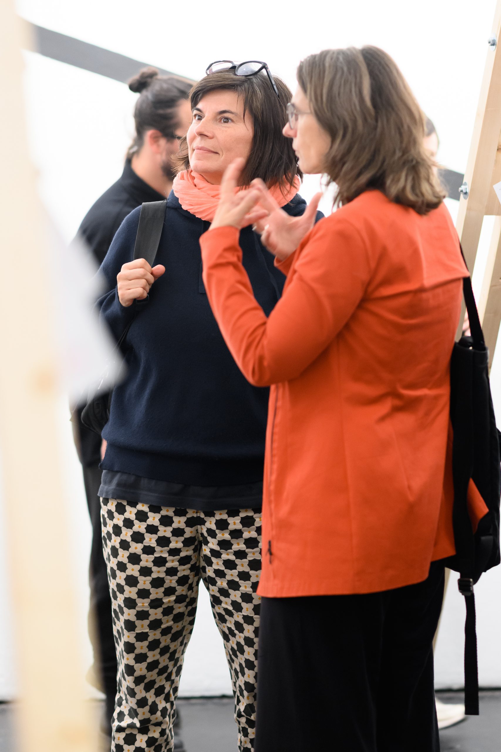 2 women, one of them with a red jacket and the other with glasses on her head