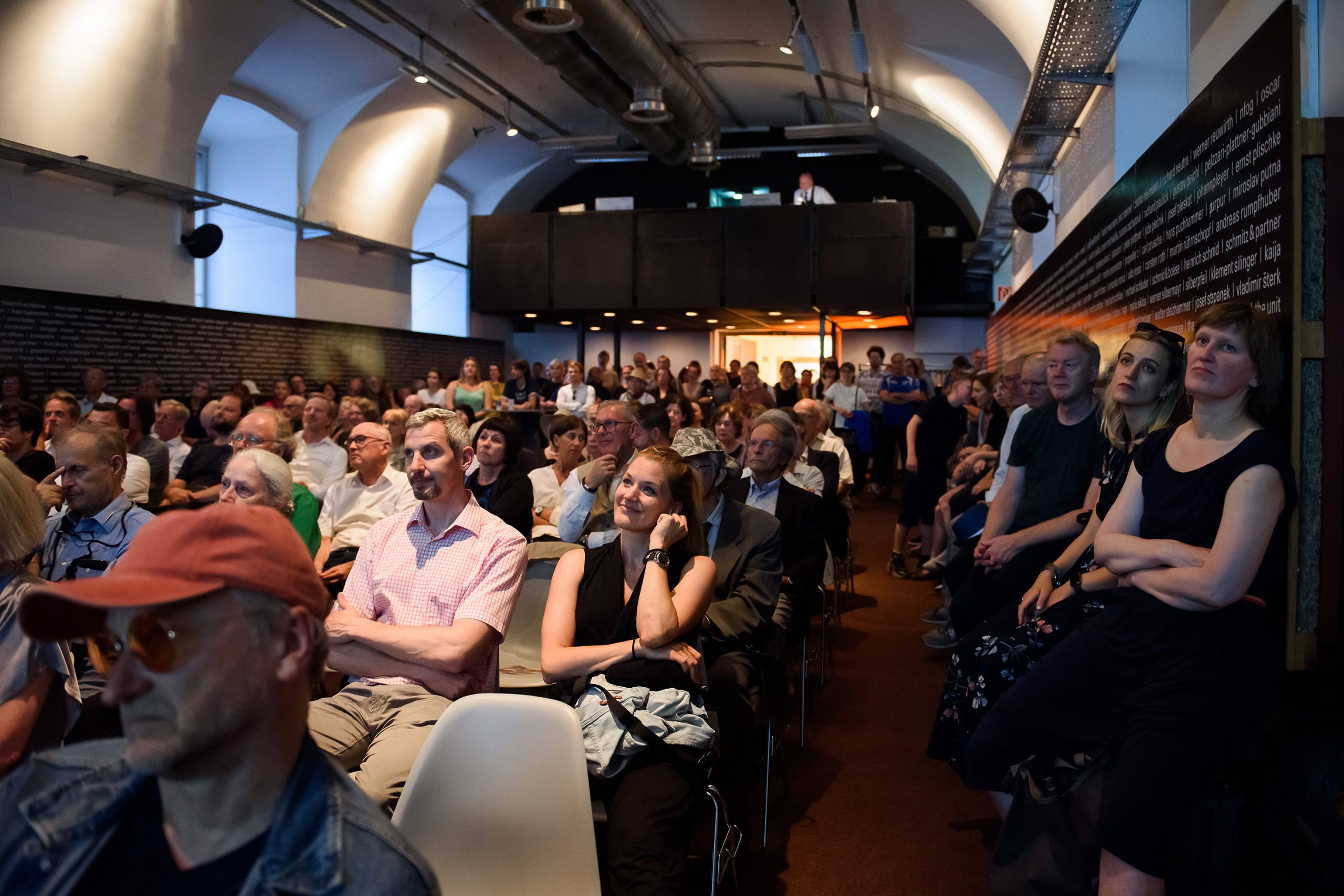 many people sitting on armchairs in a dark room