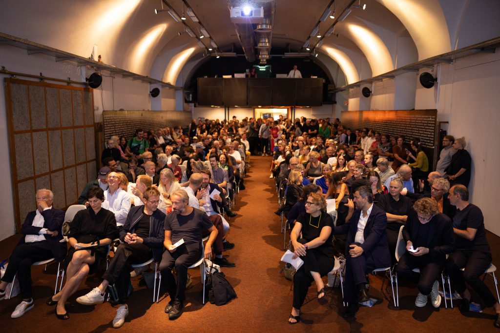 viele Menschen die auf Sesseln sitzen in einem Raum