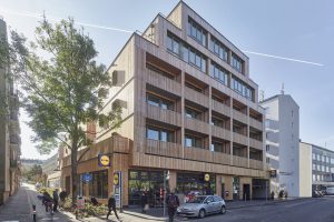 Multi-storey building in timber construction, with a supermarket on the ground floor