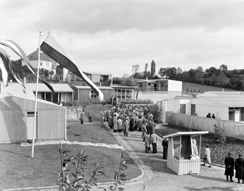 black and white photo with a crowd of people and low houses