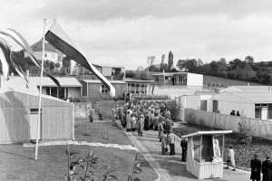 black and white photo with a crowd of people and low houses
