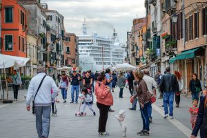 People in a pedestrian zone, behind them you can see a large cruise ship