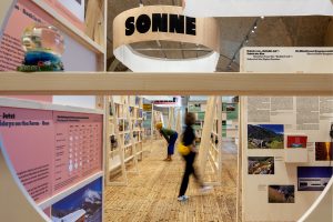 Exhibition hall with 2 people and the sun sign